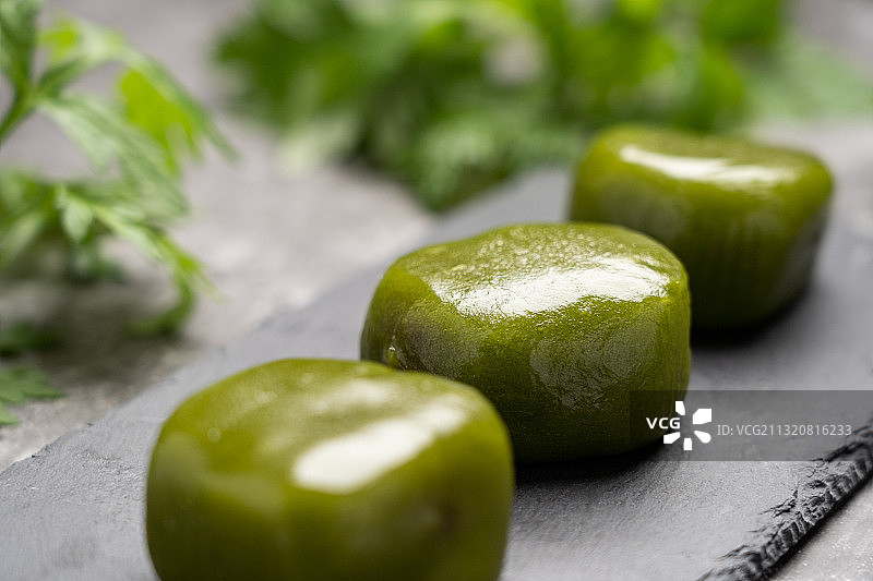 低调灰色背景清明小吃点心美味艾饼糍粑青团和原材料艾草艾叶图片素材