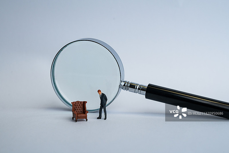 一个穿西服的男士站在一张空椅子边图片素材