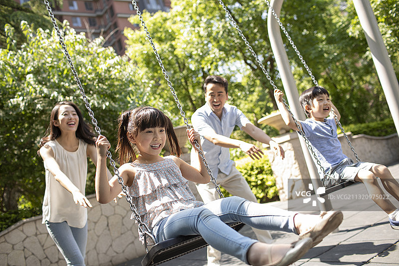 快乐的年轻家庭荡秋千图片素材