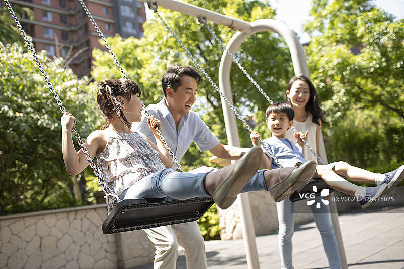 快乐的年轻家庭荡秋千图片素材