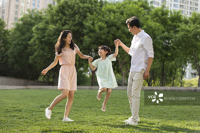 快乐的年轻家庭在公园玩耍图片素材