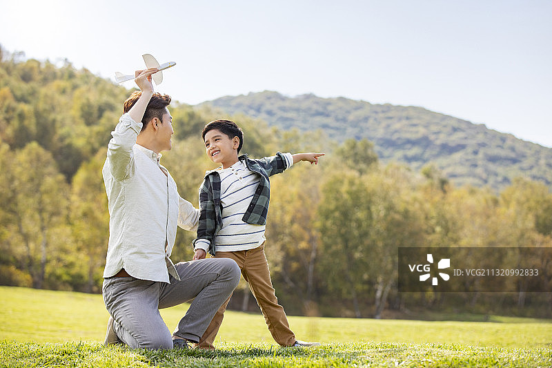 快乐的的父子俩在草地上玩耍图片素材