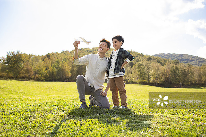 快乐的的父子俩在草地上玩耍图片素材