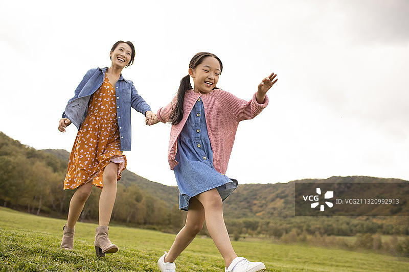 快乐的的母女俩在草地上玩耍图片素材