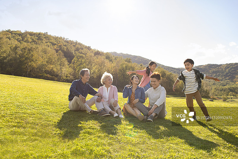 快乐的的家庭在草地上玩耍图片素材