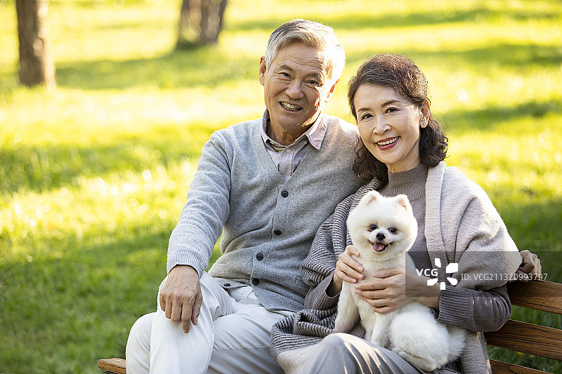 开心的老年夫妇和可爱的小狗图片素材