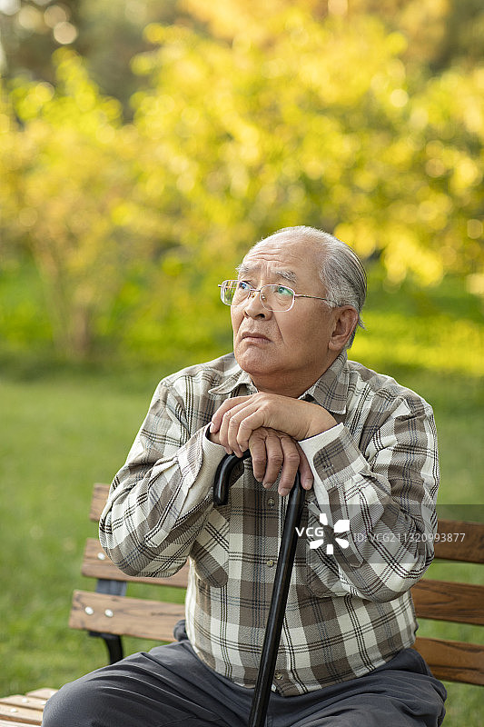 孤独的老人坐在公园长椅上图片素材