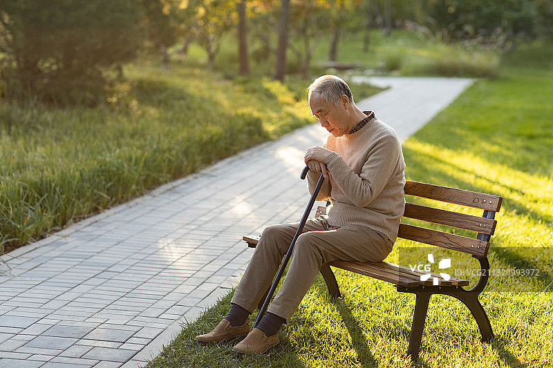 孤独的老人坐在公园长椅上图片素材