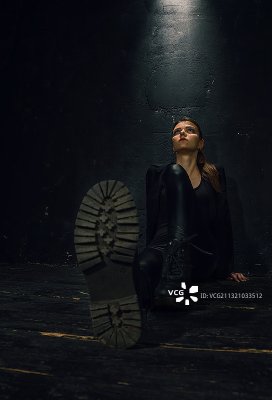 年轻女子靠墙坐着向上看，乌克兰图片素材