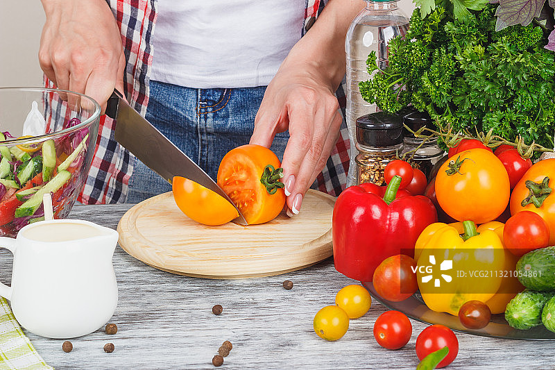 女子在桌子上切蔬菜的腰部特写图片素材