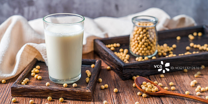 洒在桌面上的许多大豆和一杯豆浆图片素材