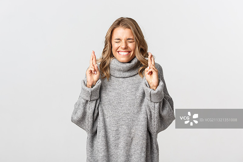 在白色背景下手势微笑的女孩的肖像图片素材