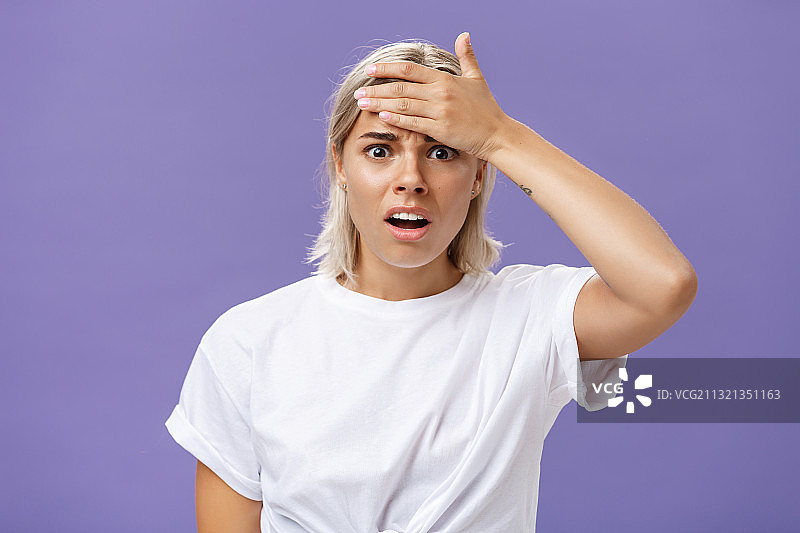 紫色背景下的震惊年轻女子肖像图片素材