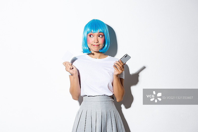 在白色背景下使用手机的戴口罩女孩图片素材