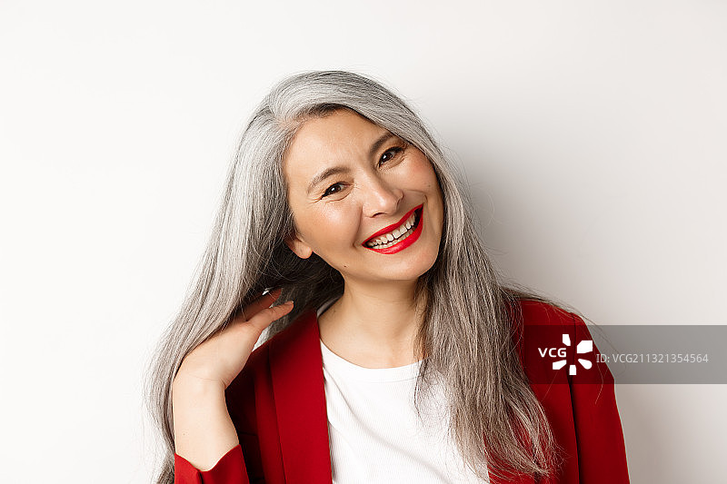 穿连衣裙站在白色背景前的微笑女性肖像图片素材