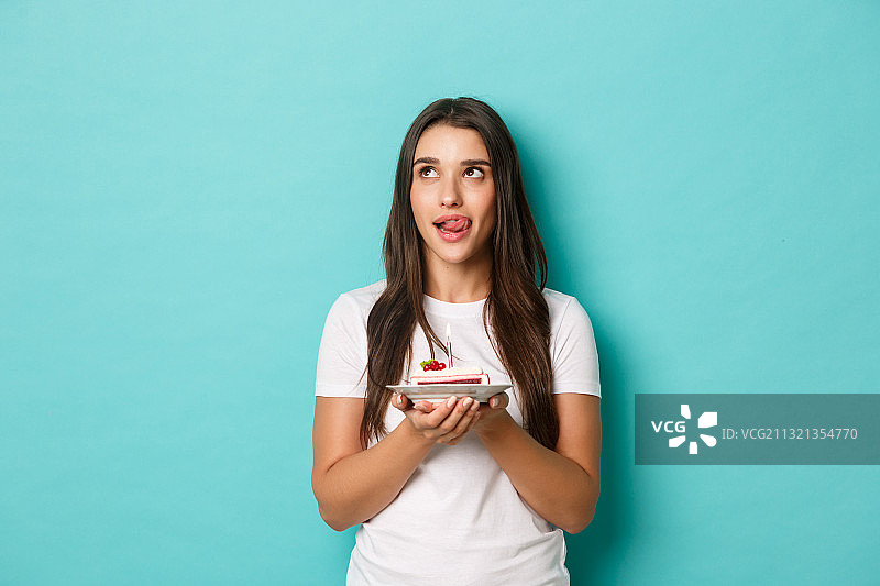 年轻女人在蓝色背景前拿着冰淇淋图片素材