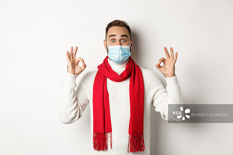 戴外科口罩并做手势的年轻女性肖像，白色背景图片素材