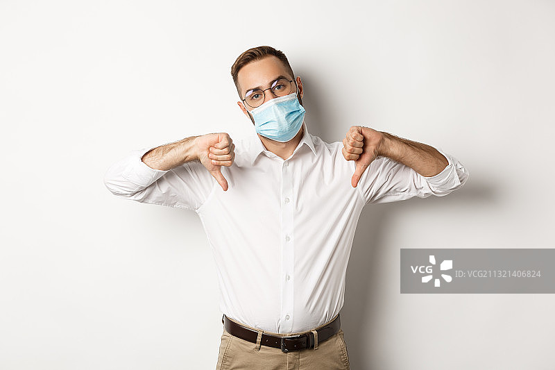 白色背景下戴外科口罩的男人肖像图片素材