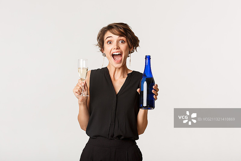 手持香槟酒杯的微笑年轻女性肖像，背景为白色图片素材