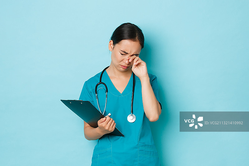 女医生站在蓝色背景前图片素材