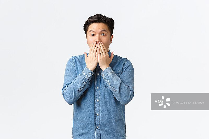 震惊的男人捂住嘴巴的肖像，白色背景图片素材