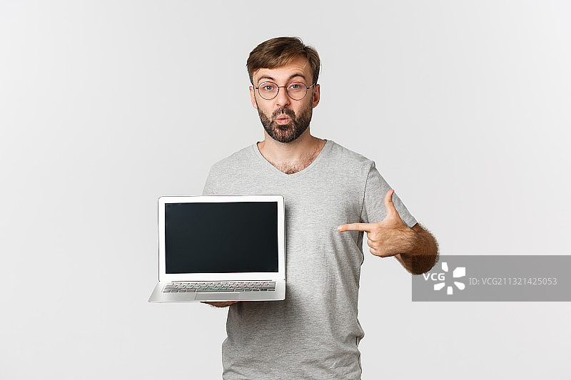 男子拿着笔记本电脑的肖像，白色背景图片素材