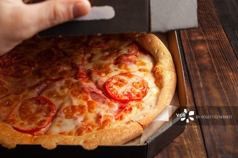 人物手持桌上的披萨，摩尔多瓦图片素材