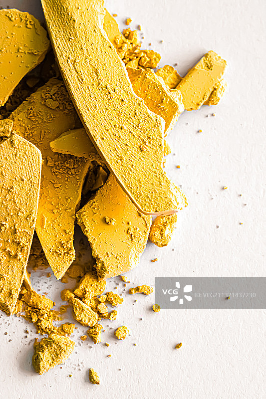 白色背景上的黄色颜料特写图片素材