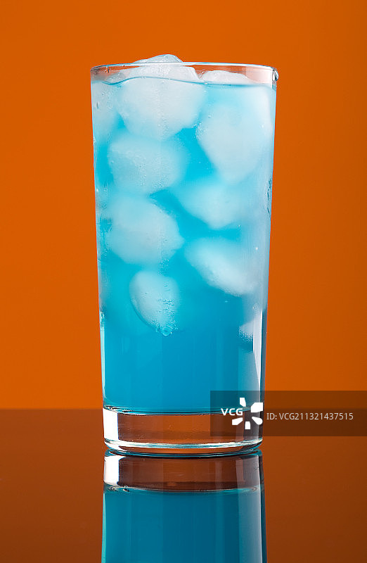 橙色背景下的玻璃杯饮品特写图片素材