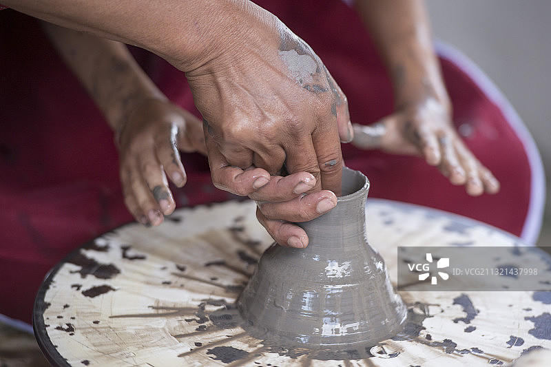 陶艺家在陶轮上制作陶罐的局部照片图片素材