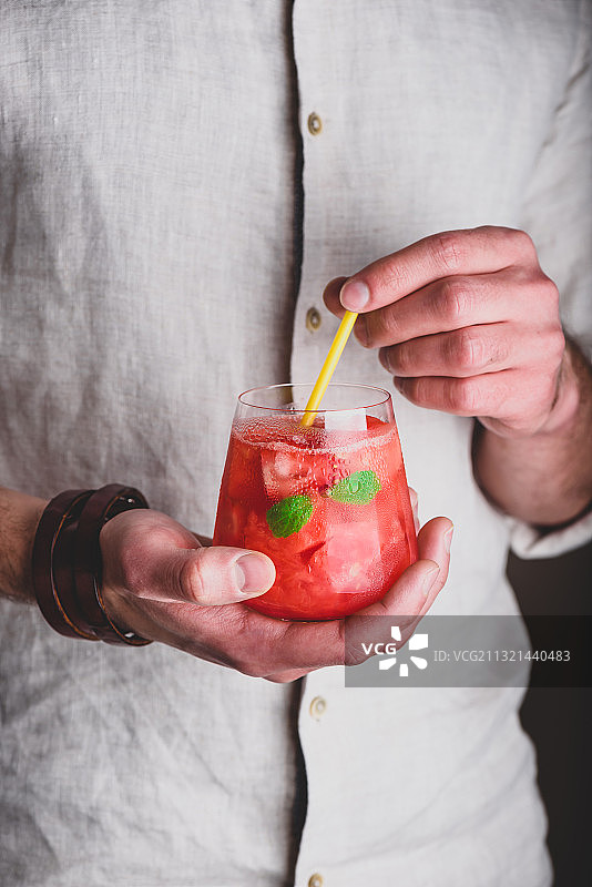 男人拿着玻璃杯里的饮料图片素材