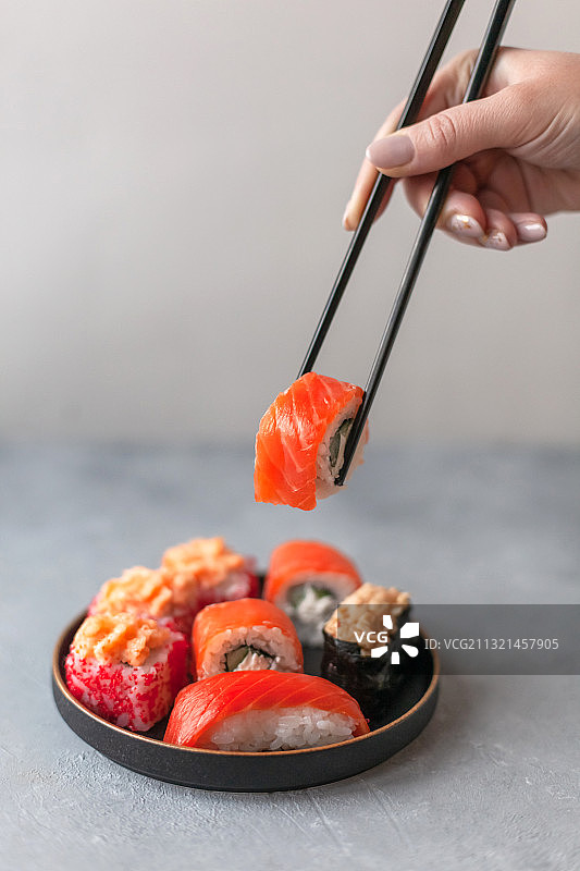 女子用筷子夹寿司图片素材