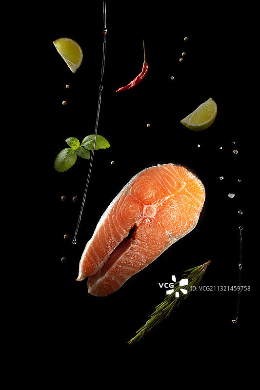 黑色背景上的鱼和柠檬片特写图片素材