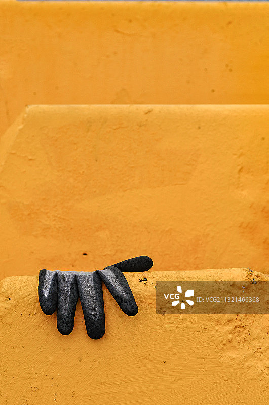 瑞典维斯比，挡土墙上的黄色手套特写图片素材
