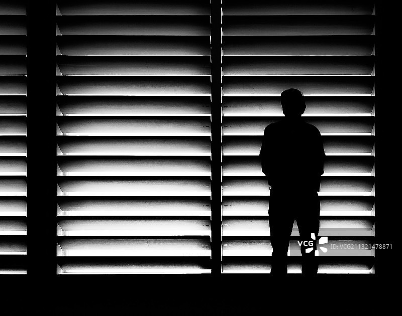 站在家中窗户旁的男人轮廓图片素材