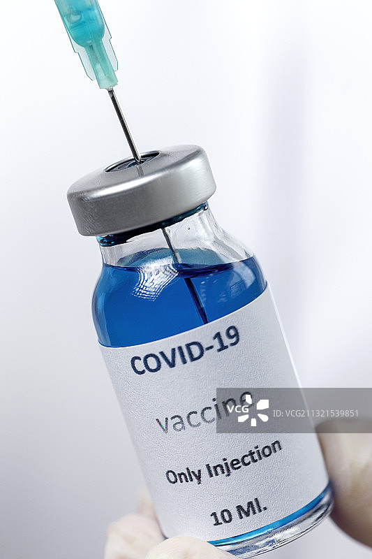 医生手持注射器和药瓶的裁剪图，白色背景图片素材