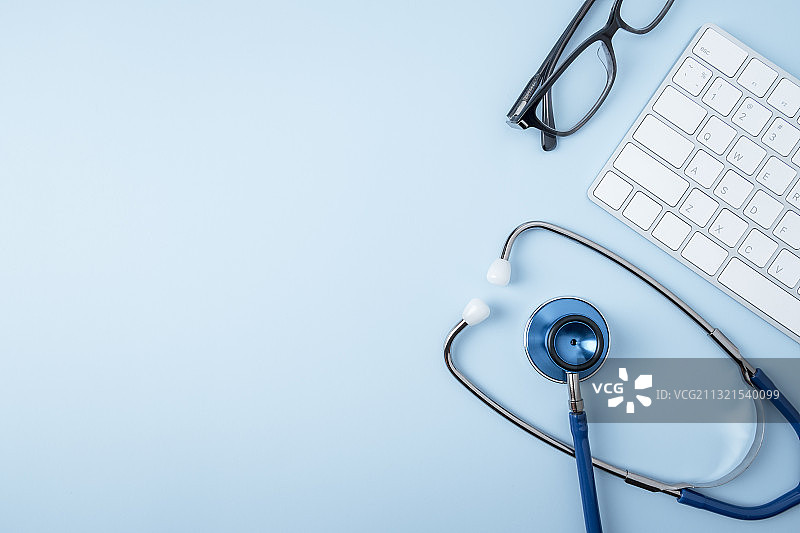泰国曼谷蓝色背景上的听诊器、键盘和鼠标（高角度拍摄）图片素材