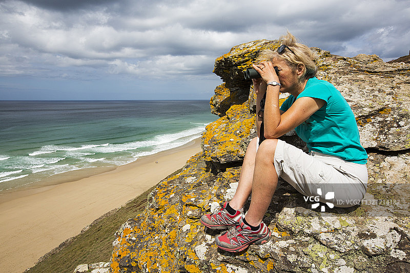 在英国康沃尔郡圣艾格尼丝的悬崖上观海的女人图片素材