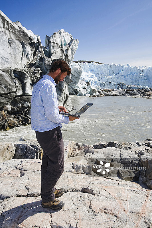 博士科学家伊恩·巴塞洛缪在格陵兰岛康克鲁斯瓦格附近测量罗素冰川的速度，作为研究的一部分进行测量图片素材