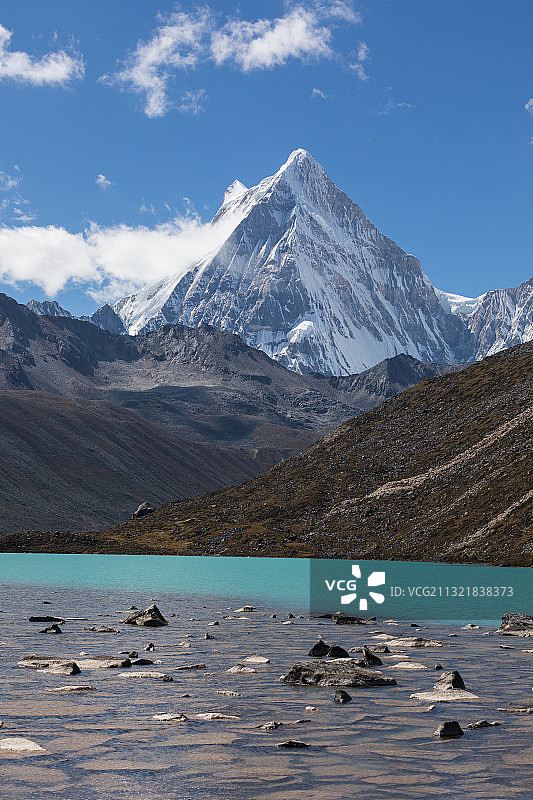 高原湖泊后面的蓝天白云尖状雪山图片素材