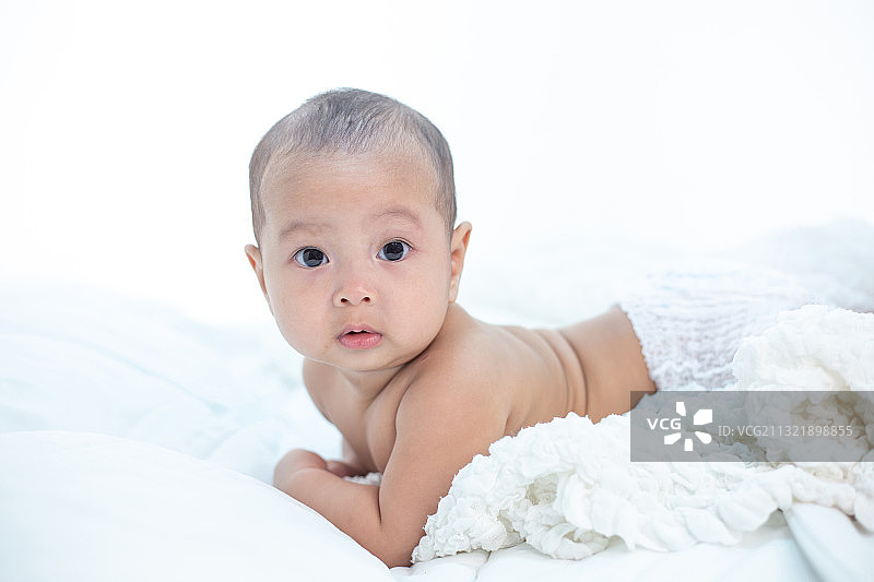 在家躺在床上的可爱男婴肖像图片素材