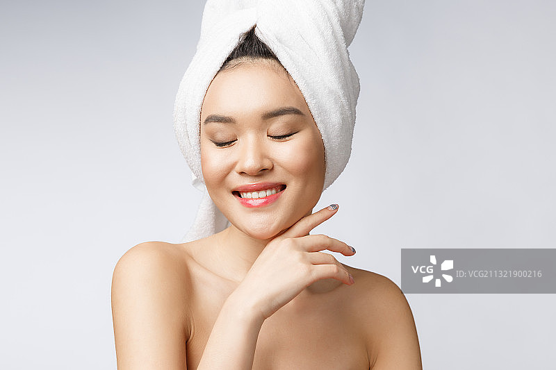 年轻女子闭着眼睛，灰色背景图片素材