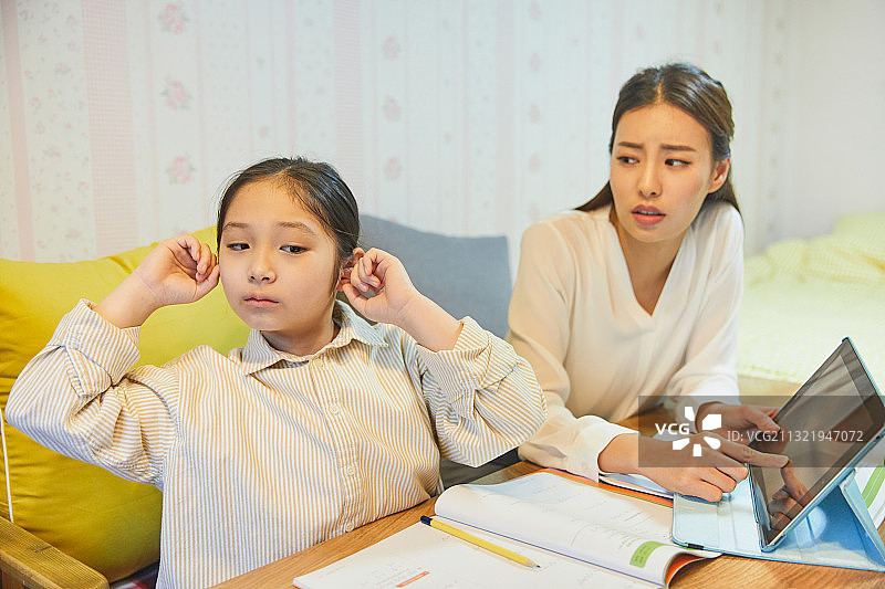 小学生在家学习，用手指堵住耳朵，表现出漠不关心图片素材