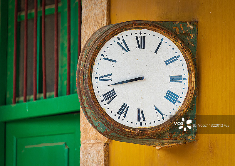 云南碧色寨法式风情的火车站，斑驳的黄色外墙和绿色的古老时钟图片素材