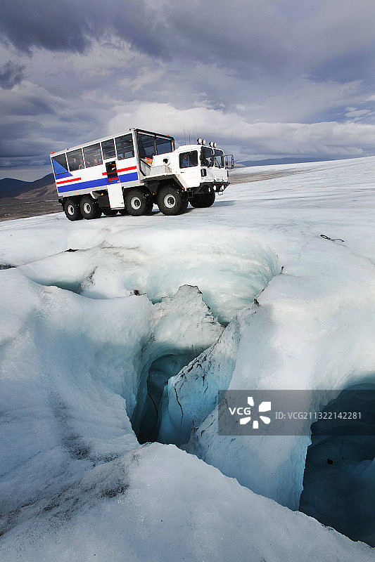 在冰岛兰 glacier冰盖上，一辆20吨重的冰地探险车搭载游客图片素材