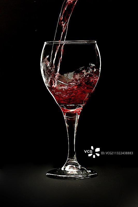 红酒倾倒入酒杯图片素材