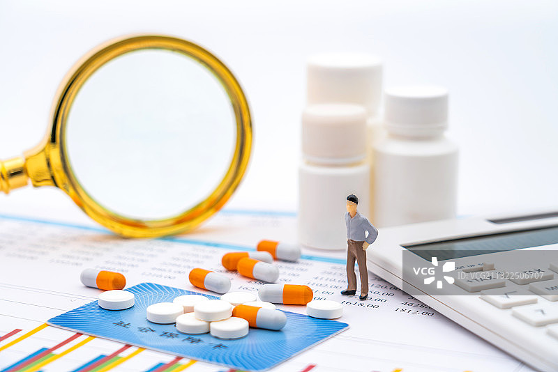 药品、放大镜、医保卡和玩具小人——医疗保险概念图片素材