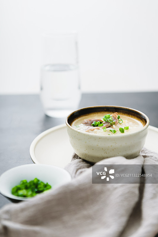 窗户边上的美味瘦肉粥和一杯水图片素材
