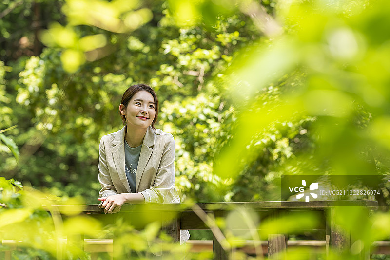 靠在森林栏杆上的女人图片素材