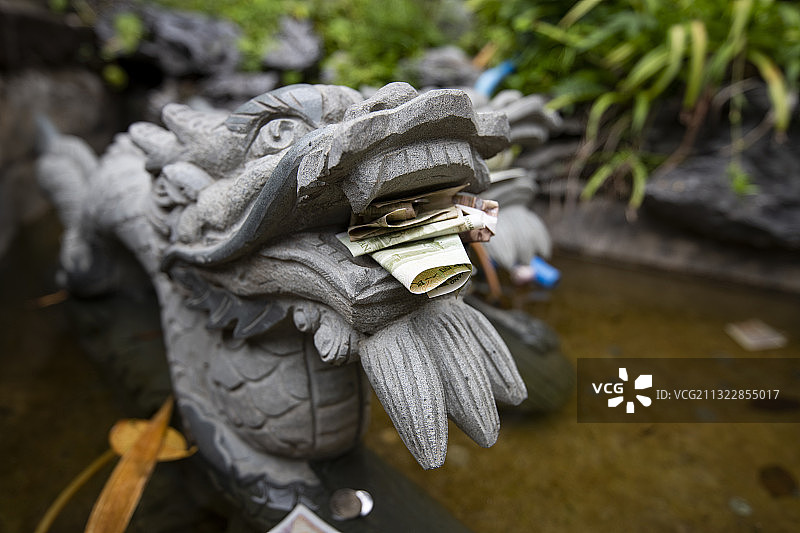 广州南海神庙的石雕龙头里塞着钱图片素材